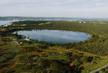 Vista aérea do Lago Paranoá, em Brasília, cercado por áreas verdes.